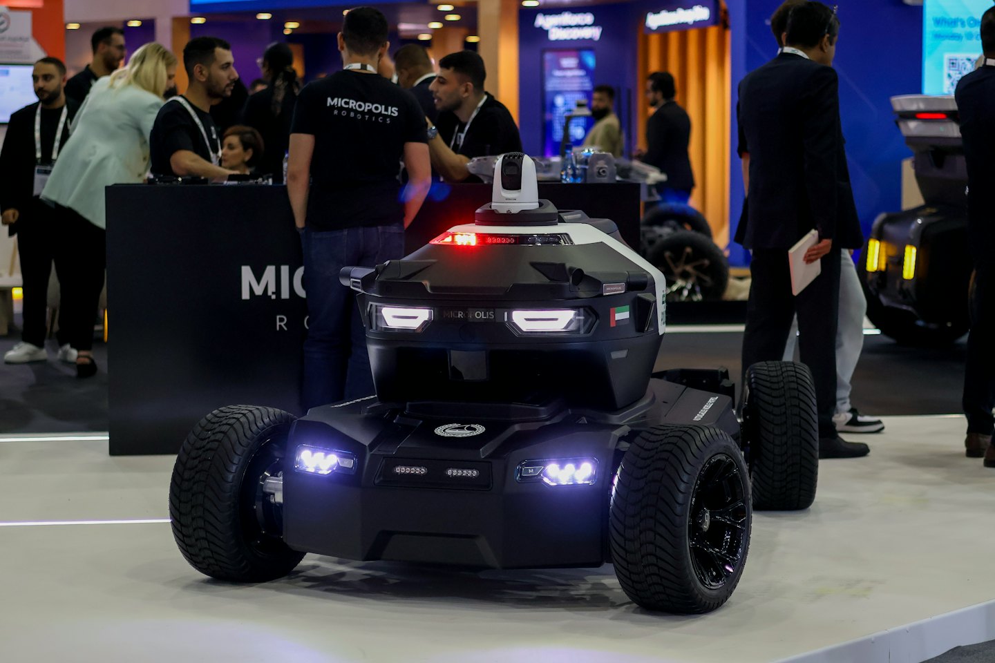 Robotic vehicle with a sensor on display at a technology exhibition.
