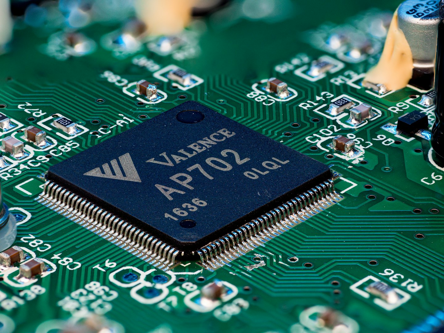 Electronic components and a microchip on a green circuit board.