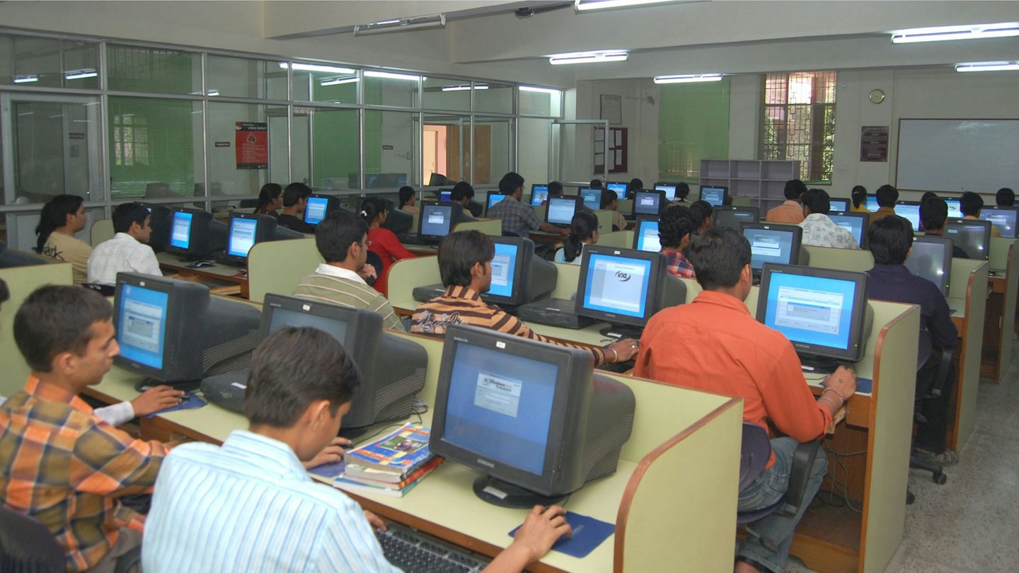 Young adults working on computers in a lab.